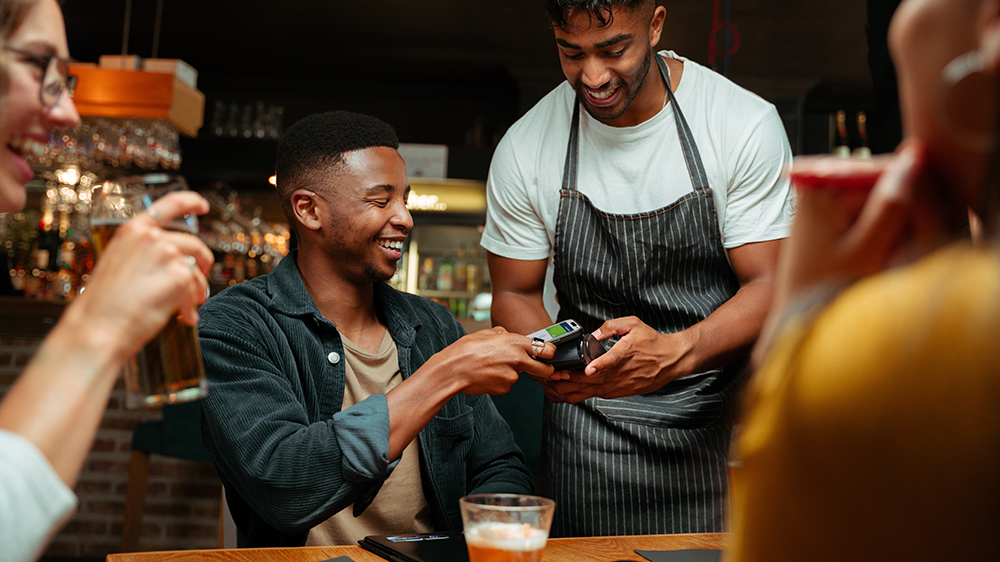 person making payment at restaurant with phone
