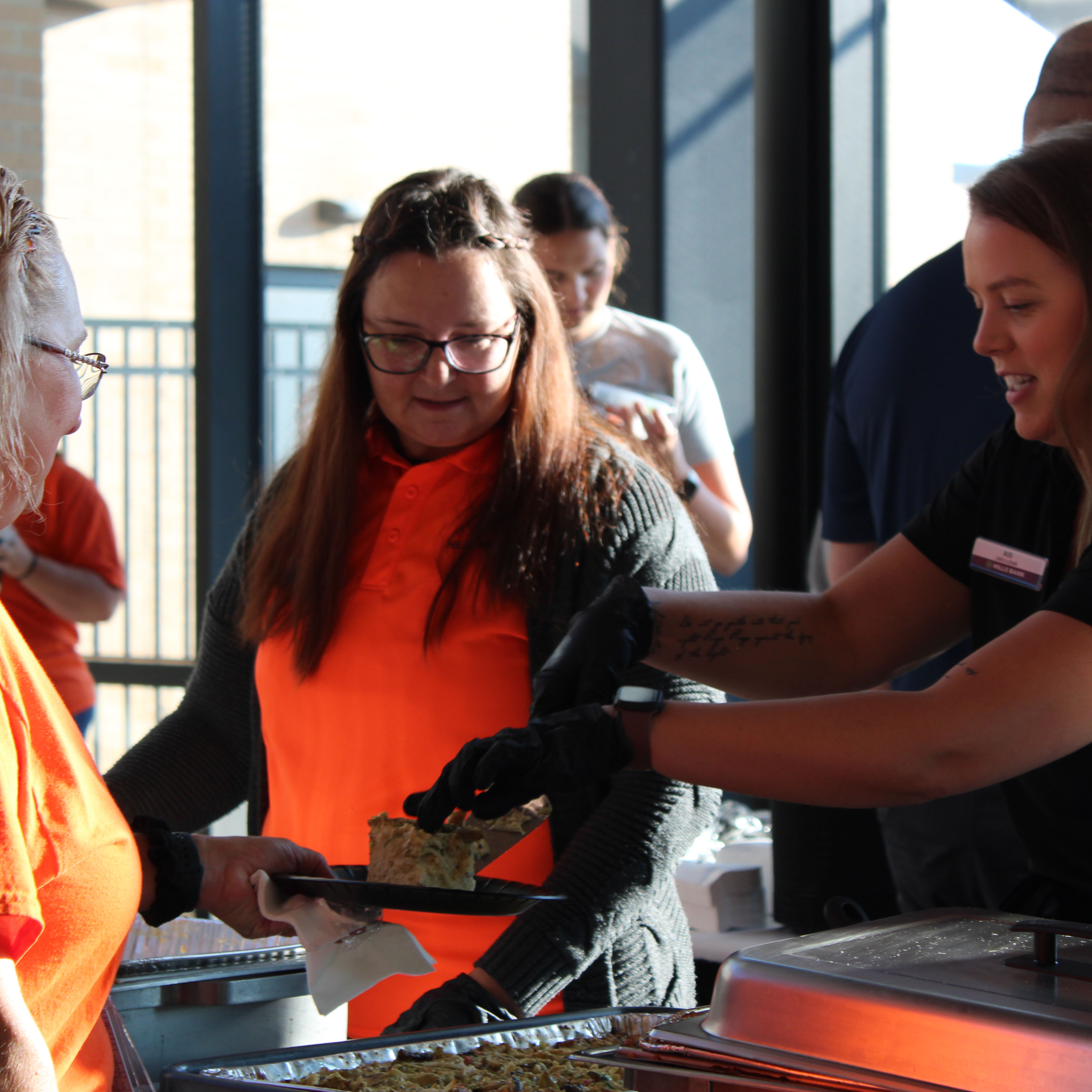 Hills Bank employees serving breakfast to a local teacher.