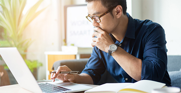 Man thinking looking at laptop