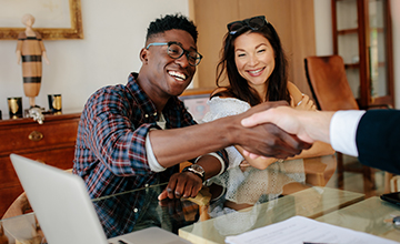 black man shakes hand with person across desk