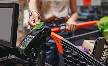 woman using hills bank debit card to make purchase at grocery store